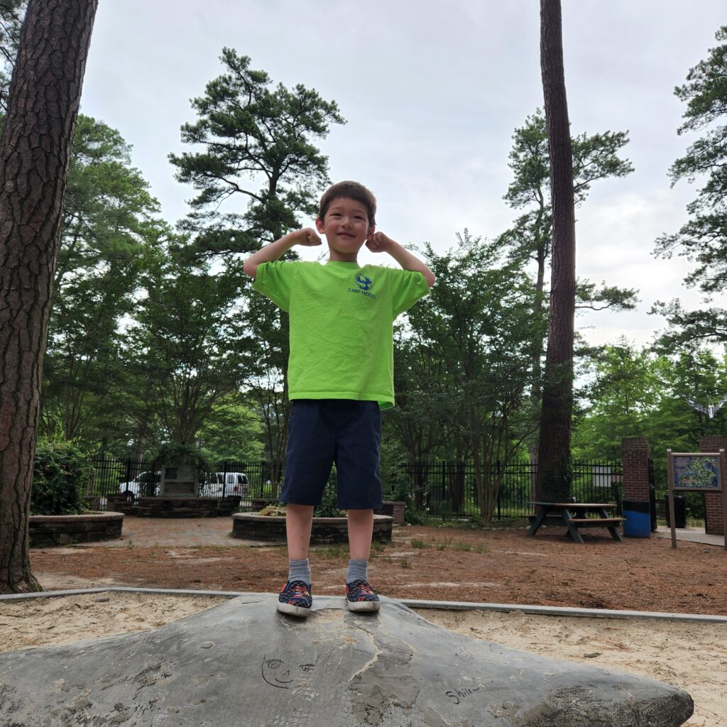 kid on a rock flexing